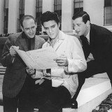 Mike Stoller, Elvis Presley and Jerry Leiber studying "Jailhouse Rock" song sheet
