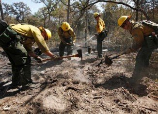 Firefighters from the Lassen National Forest in Calif are cleaning hot spots in Bastrop Texas (Photo: Eric Schlegel - POOL / AP)