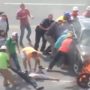 Bystanders lifted a burning car off a motorcyclist trapped underneath.