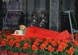 North Korean state television showed still images of the Kim Jong-Il body in the open coffin, surrounded by wreaths and covered with a red blanket
