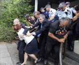 About 50 police escorted PM Julia Gillard and Tony Abbott from Canberra's Lobby restaurant after it was surrounded by some 200 supporters of the city's Aboriginal Tent Embassy
