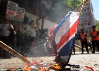 Around 100 left-wing activists have protested by burning Union flags outside the British embassy in Buenos Aires on Friday to demand Argentina break off diplomatic relations with the UK over the Falkland Islands dispute