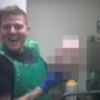 Shocking picture: embalmer David Amor laughing as he holds aloft a severed head