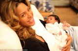Beyoncé is seen beaming into the camera while she cradles her daughter Blue Ivy in her arms
