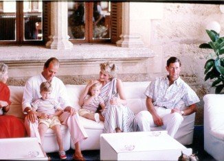 In one picture, King Juan Carlos of Spain sits with the small Prince William, while a radiant Princess Diana, a protective arm round toddler Prince Harry, leans in to share a pleasantry with the good-looking monarch