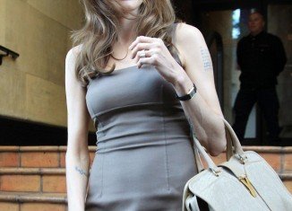 Angelina Jolie is getting used to wearing her huge engagement diamond as she headed to a meeting yesterday