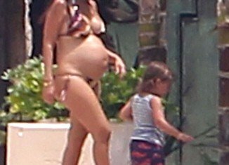 Kourtney Kardashian revealed her baby bump by slipping into a bikini on holiday