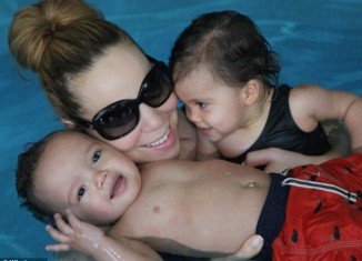 Mariah Carey had one arm wrapped around daughter Monroe while the other held onto Moroccan, who was floating in the water
