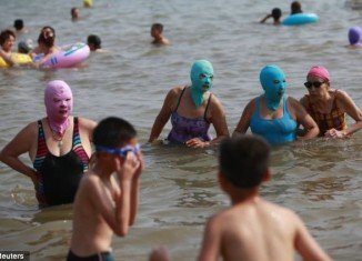 Beach-goers in Qingdao are donning slightly scary nylon masks to protect themselves when they take to the sand