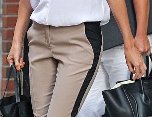 Miranda Kerr has been spotted creating the illusion of a skinnier size thanks to a dark panel down the side of the trousers
