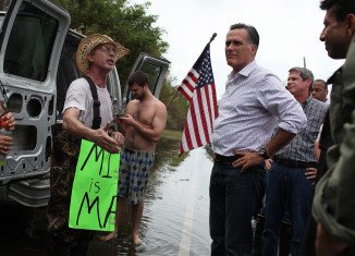 Mitt Romney has visited an emergency centre in hurricane-damaged Louisiana