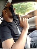Nick Gordon is seen holding the firearm up to his face while driving a car using the other hand