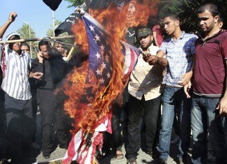 Palestinians burn a US flag during a protest against the movie, Innocence of Muslims, near the UN office in Gaza City