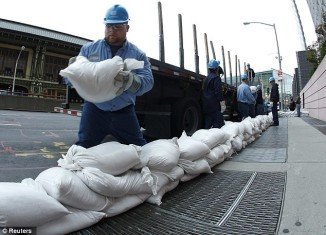 Con Edison workers prepare for Hurricane Sandy using sandbags to cover up power vaults in New York