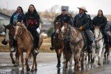 Family and friends of Russell Means sing as they ride horses down the Big Foot Trail during a 12 hour service in North Dakota on Wednesday