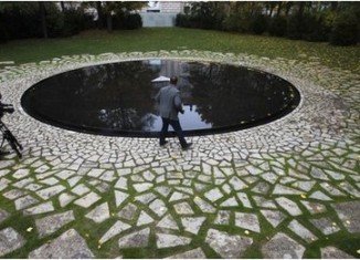 Roma Holocaust memorial is a circular pool of water with a small plinth in the middle in the Tiergarten park, near the Reichstag