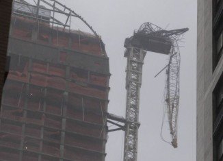 The storm engulfing New York has ripped a crane off the top of a 65-story luxury building and torn the face off an apartment in the West Village