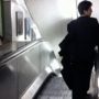 Drunk businessman trying to walk wrong way down escalator