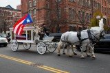 A carriage drawn by white horses carried Hector Camacho's body around the streets of Spanish Harlem, taking the casket cover with a Puerto Rican flag to St. Cecilia's Catholic Church