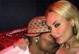 Coco Austin smirking at the camera and wrapping her arm around AP.9 as he plants a kiss on her cheek and burrows his face in her neck