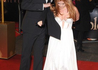 Isla Fisher stole the show from her husband Sacha Baron Cohen in daring plunging white gown at the London premiere of Les Misérables