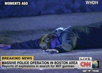 Boston police arrested a suspect at gunpoint after multiple shots and explosions were heard in the suburb of Watertown, hours after a MIT campus police officer was shot dead