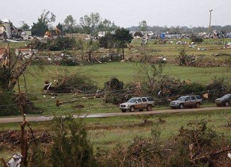 At least one person is reported dead and at least 21 others injured in a series of tornadoes that have torn through Oklahoma and Kansas.