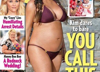 Kim Kardashian shows off her blossoming baby bump in a bikini as she proves fat critics wrong