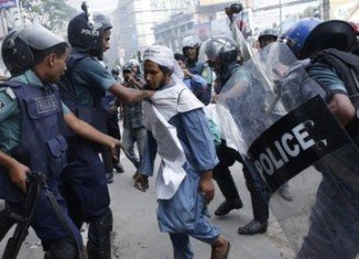 Up to half a million protesters gathered in Dhaka, where rioters set fire to shops and vehicles as police fought to contain them