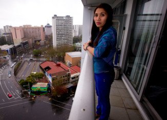 Geraldine Bautista on the 15th floor balcony from which she tried unsuccessfully to save Tom Stilwell who fell 13 floors outside the Volt apartment block in downtown