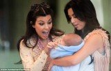 Kim Kardashian posted a Facebook picture of herself and sister Kourtney cooing over a new born baby