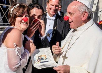 Pope Francis donned a bright red nose and clowned around with a newlywed couple inside the Vatican
