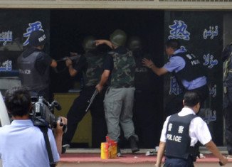 Two police officers and nine axe-wielding assailants have been shot dead during an attack on a police station in China's volatile western Xinjiang province