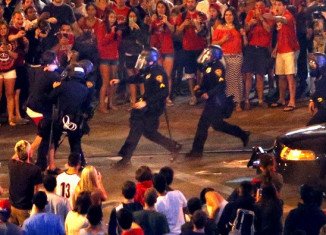 Tucson police shot pepper spray at several hundred fans who took to the streets after Arizona's overtime loss