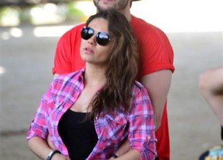 Mila Kunis showed off her baby bump as she attended the Stagecoach Music Festival in Indio, California, with Ashton Kutcher