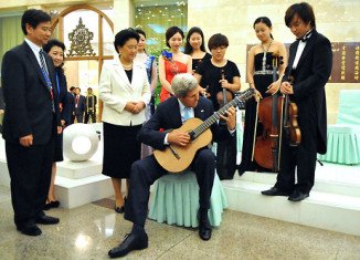 John Kerry played a musician's guitar following a lunch at the Great Hall of the People in Beijing