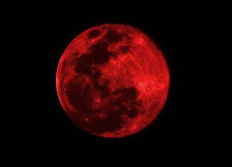 The Moon appears orange or red, the result of sunlight scattering off our atmosphere, hence the name Blood Moon