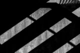 unsplash-a-black-and-white-photo-of-a-bench-in-the-shadows-101697