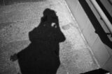 unsplash-shadow-of-a-person-holding-a-camera-on-stairs-101598